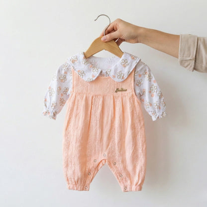 Baby romper with floral lace collar on a hanger against a white background