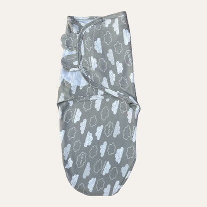 Introducing the Alaya Junior Baby Boys Newborn Summer Swaddles, a charming gray swaddle blanket adorned with white cloud patterns. This essential item for your little one features a lightweight design and convenient velcro straps, making swaddling both effortless and stylish.