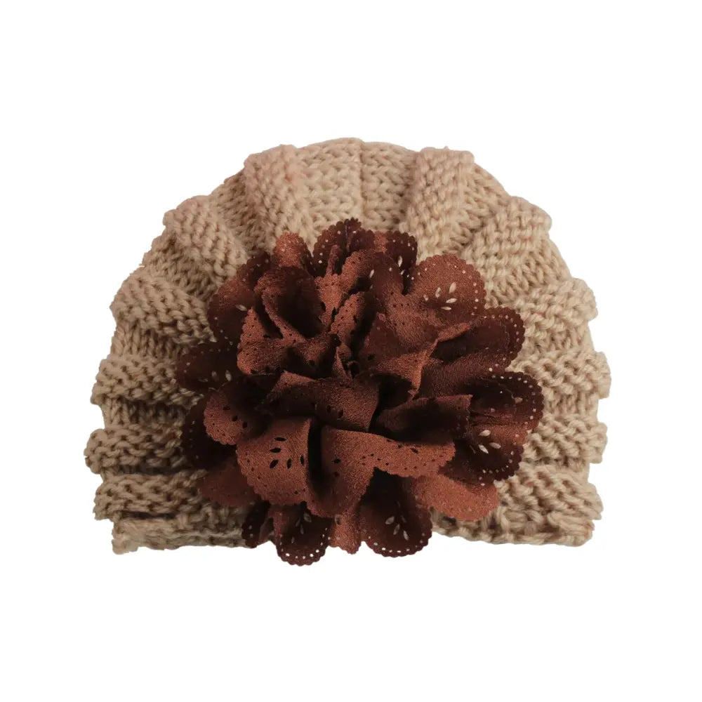 Introducing the Baby Girl Lace Flower Design Knitted Turban Cap by Alaya Junior, a versatile accessory featuring charming knitted fabric in beige with a prominent brown flower decoration at the front. Suitable for ages 0 months to 3 years.