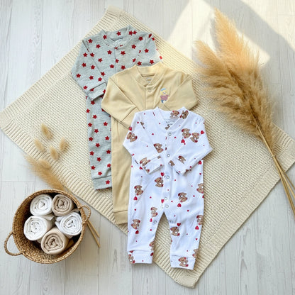 Three baby rompers with different patterns on a white background