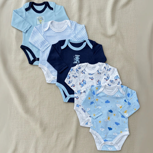 Collection of baby bodysuits in various patterns on a beige fabric background