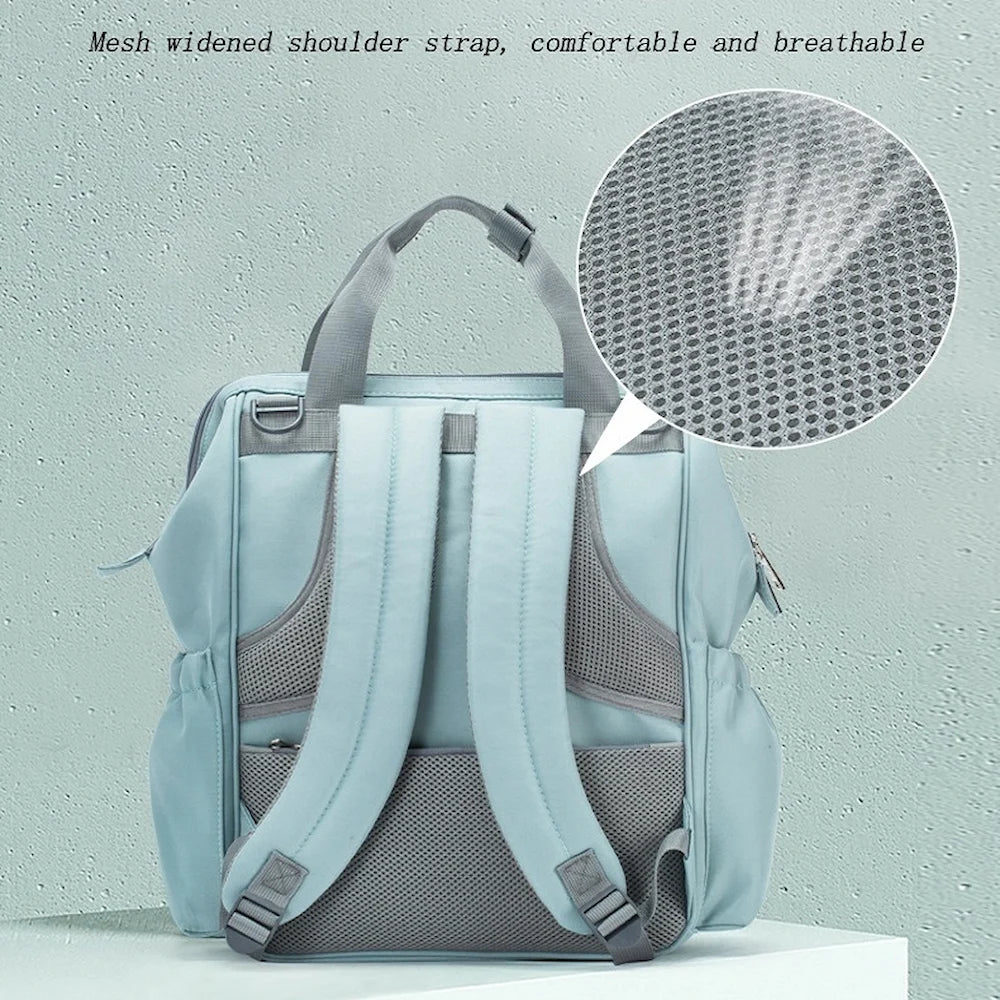 An Ellie & Luke Multifunctional Diaper Bag (Blue) by Ellie And Luke is showcased against a textured backdrop. A bubble zooms in on the mesh material of its straps with the text "Mesh widened shoulder strap, comfortable and breathable.