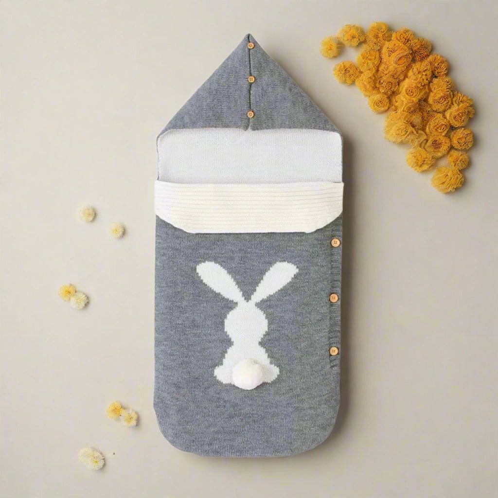 Gray baby swaddle with white bunny design on a white background
