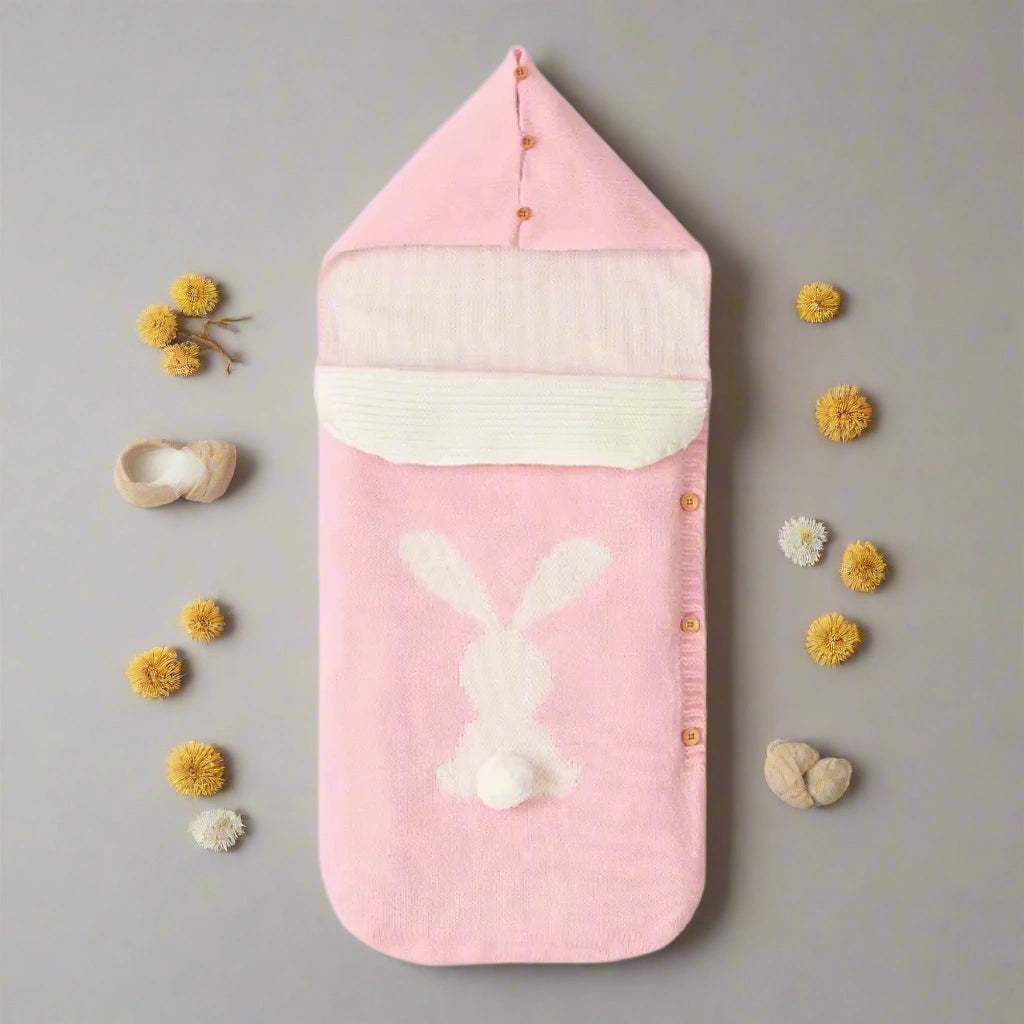 Pink baby swaddle with bunny design on a white background