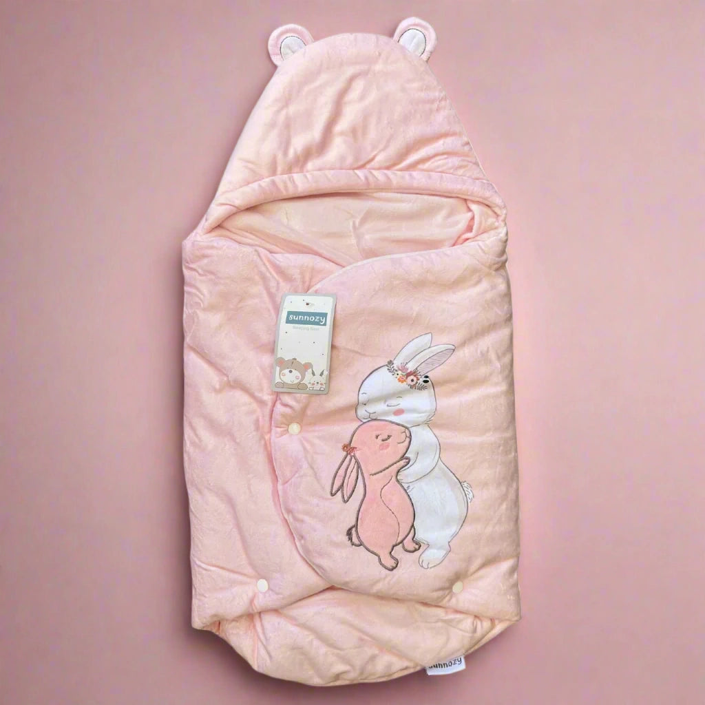 Pink baby swaddle with bunny design on a white background