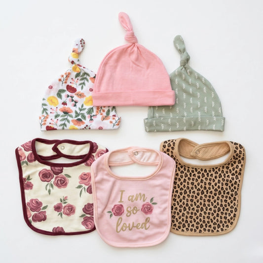 Collection of baby hats and bibs on a white background