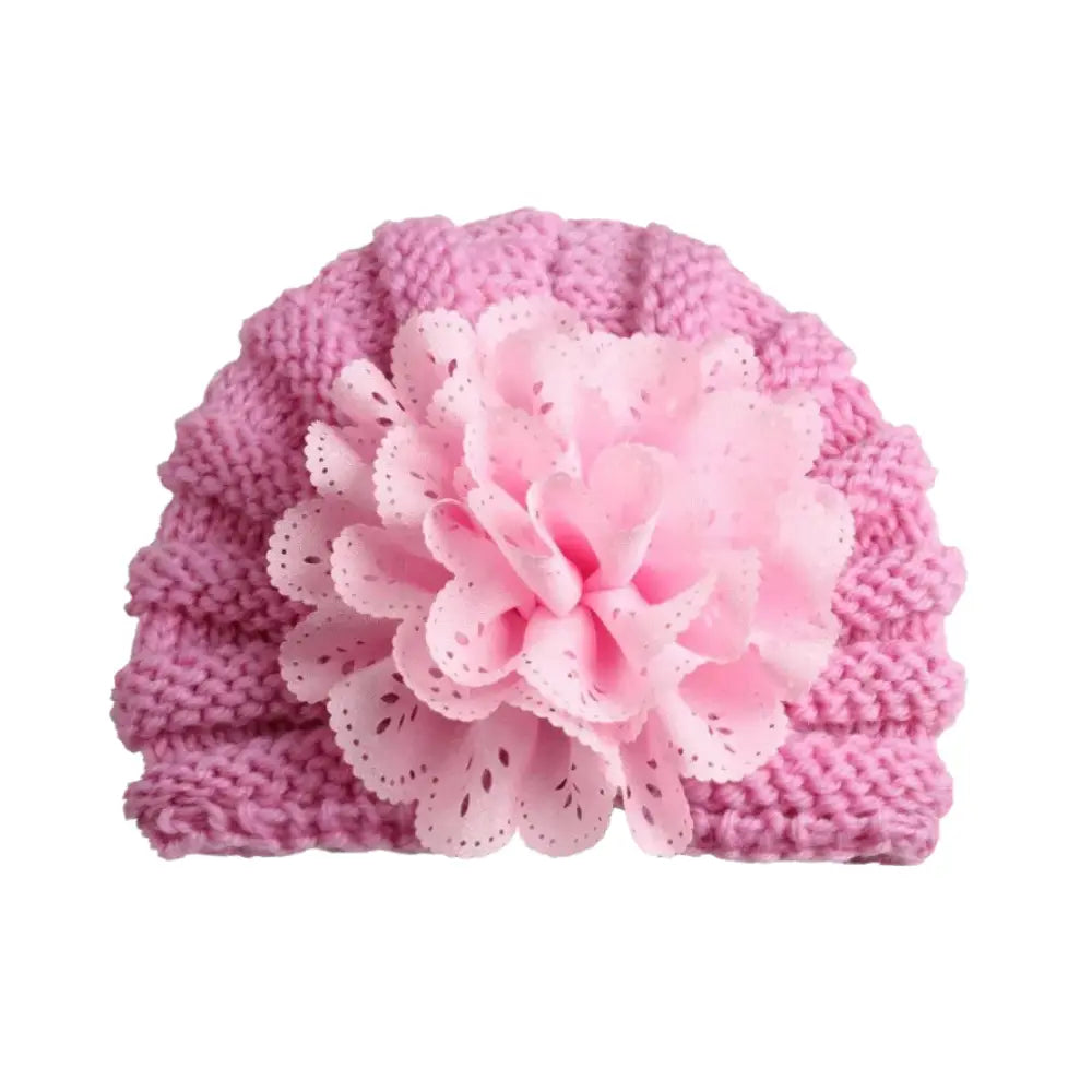 The Baby Girl Lace Flower Design Knitted Turban Cap by Alaya Junior, suitable for ages 0 months to 3 years, features a large decorative fabric flower at the front, providing a versatile accessory for your little one's wardrobe.