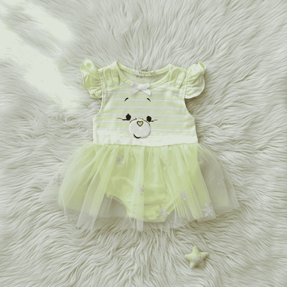 Light green baby dress with bear design on a fluffy white surface