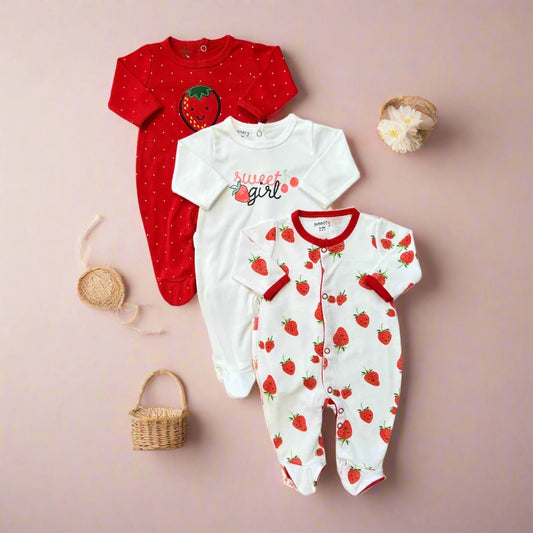 Three baby onesies with strawberry patterns on a white background