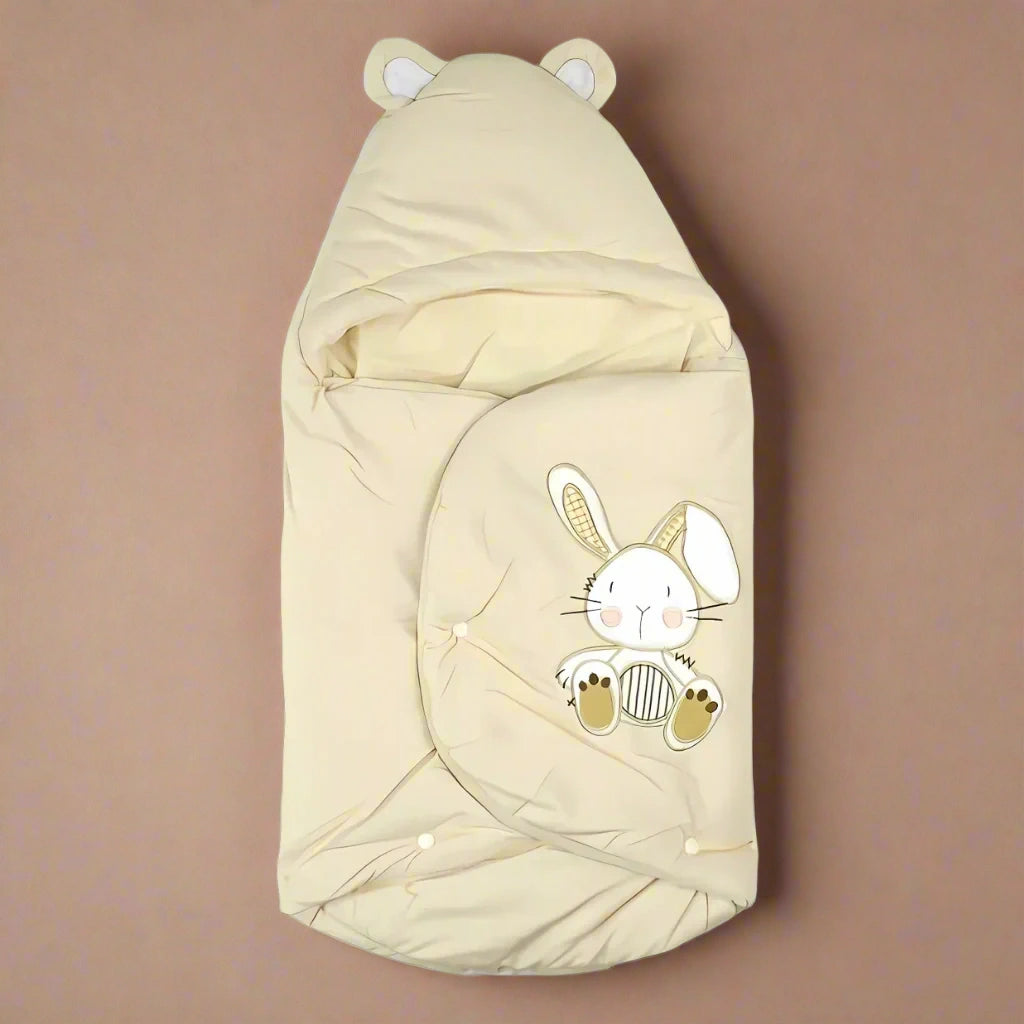 Beige baby swaddle with bunny design and ears on a white background