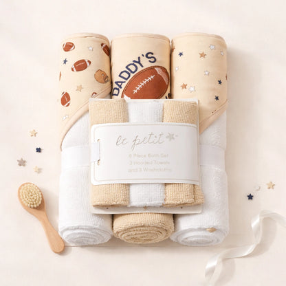 Baby洗礼用品套装，包括毛巾、尿布和小刷子，品牌'le petit'标签可见。