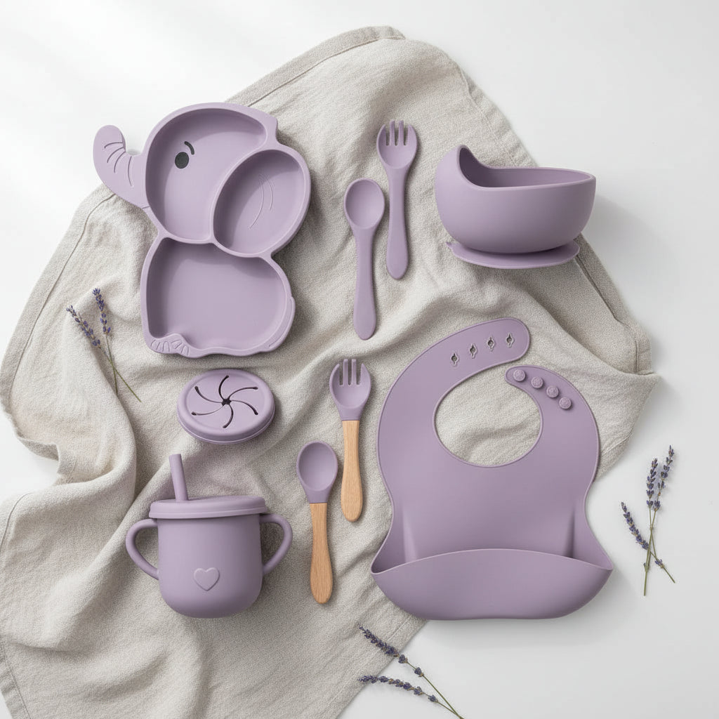 Purple baby utensil set including elephant-shaped plate, bowl, cup, bib, and various utensils on a white background