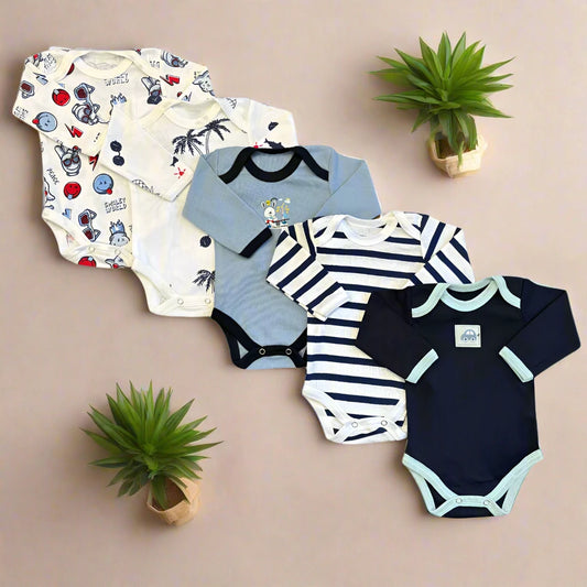 Five Carter's "Unisex Baby Full Sleeves Bodysuits Pack of 5 – Blue-Themed" are neatly arranged on a brown surface, surrounded by two small potted plants. The unisex designs feature different patterns: space-themed, palm trees, cartoon character, navy and white stripes, and plain navy with light green trim. Each bodysuit offers cotton comfort for your little one.