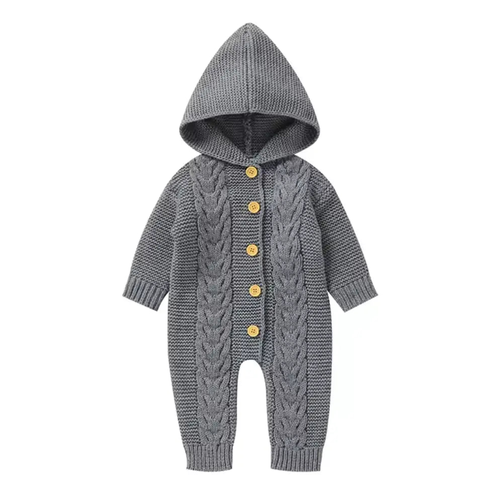 Introducing the Alaya Junior Baby Girl/Boy Knitted Pattern Hooded Jumpsuit in gray, a charming gender-neutral gift for any baby. This cozy jumpsuit features a stylish cable knit design with long sleeves and five wooden buttons down the front.