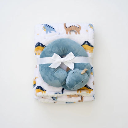 Blue hippo-shaped pillow with a white bow on a blanket with animal patterns
