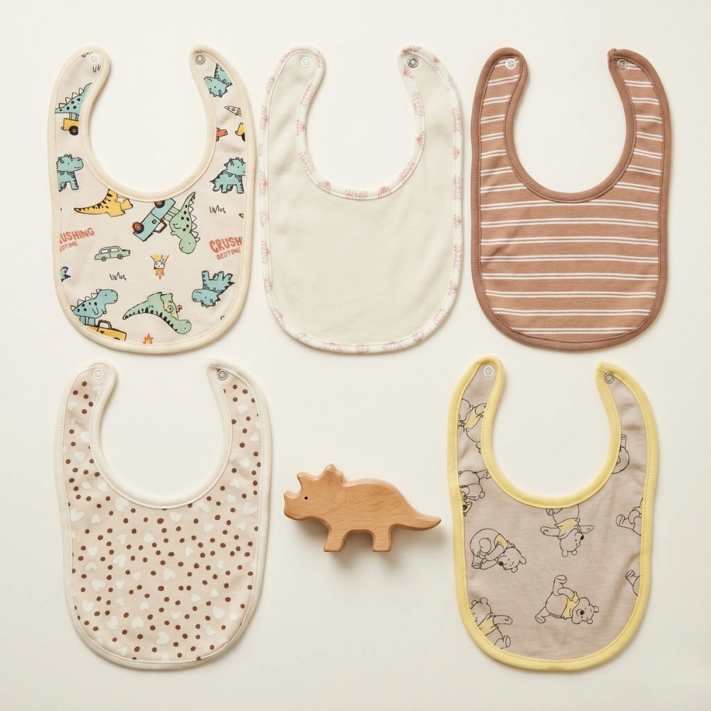 Five baby bibs with different patterns on a light background