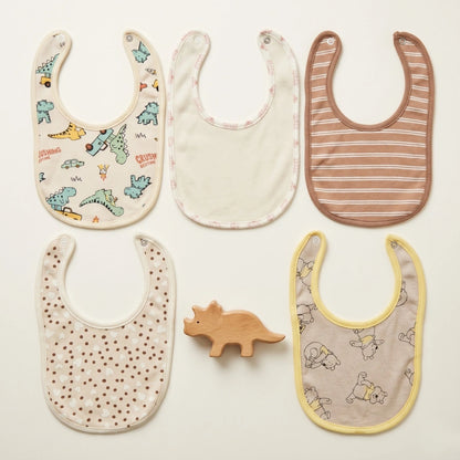 Five baby bibs with different patterns on a light background
