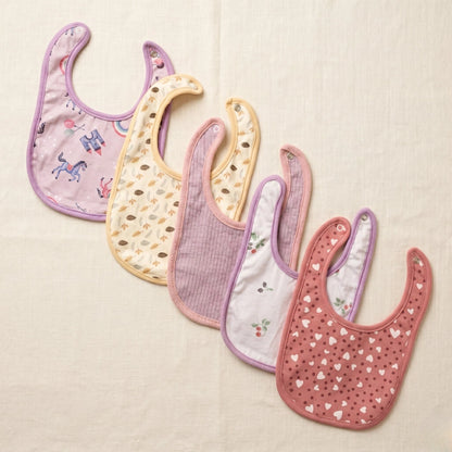 Set of five baby bibs with various patterns on a beige background