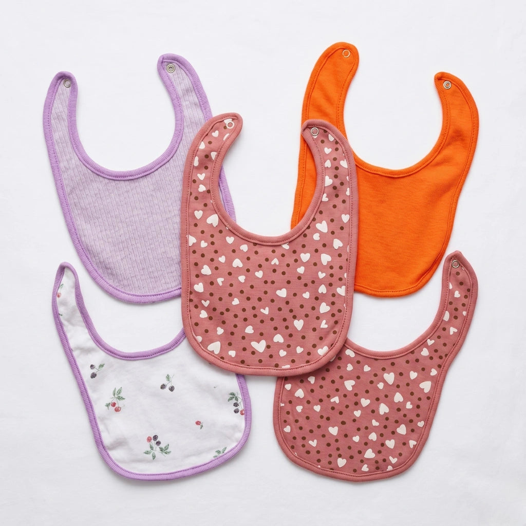 Set of colorful baby bibs on a light gray background