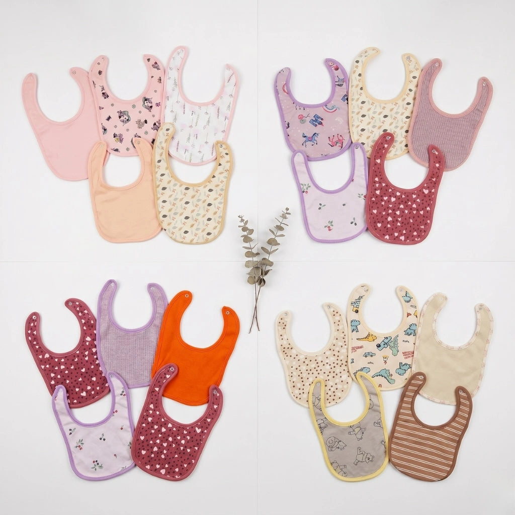 Collection of colorful baby bibs on a light background
