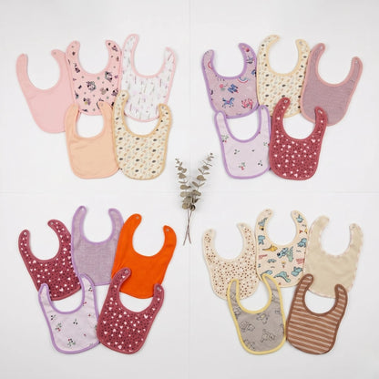 Collection of colorful baby bibs on a light background