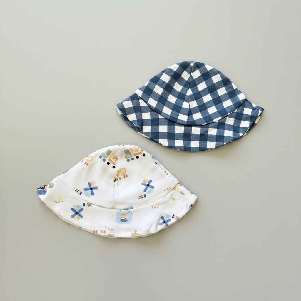 Two children's hats on a gray background, one checkered and one with cartoon designs.