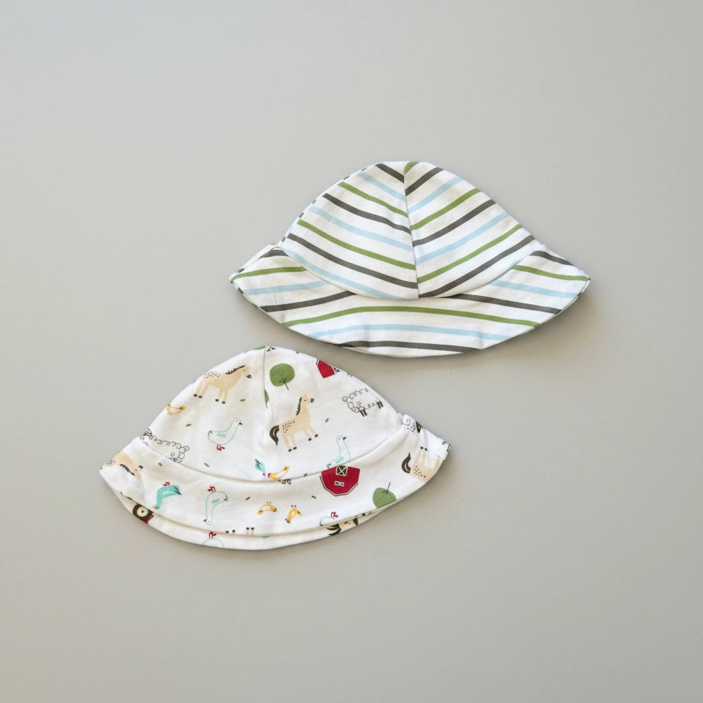 Two baby hats on a gray background, one with animal prints and the other with stripes.