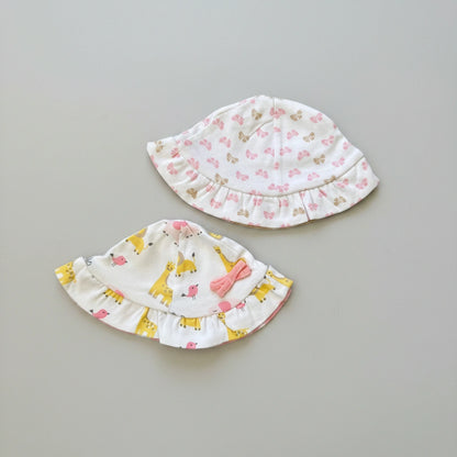 Two baby hats with floral and animal patterns on a brown background