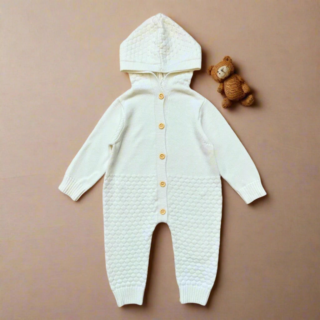 White baby onesie with a textured pattern and yellow buttons on a white background