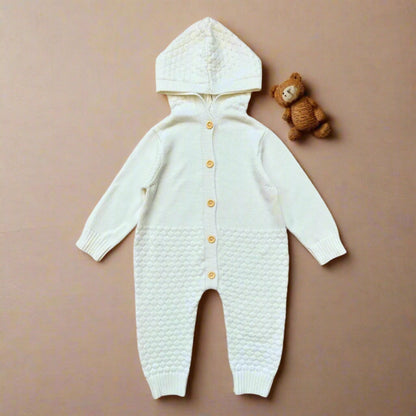 White baby onesie with a textured pattern and yellow buttons on a white background