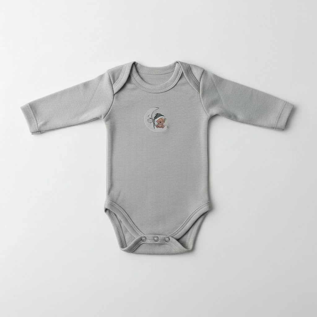 A light gray long-sleeve baby bodysuit with a small embroidered tiger logo on the chest, laid flat on a white shaggy faux fur rug.