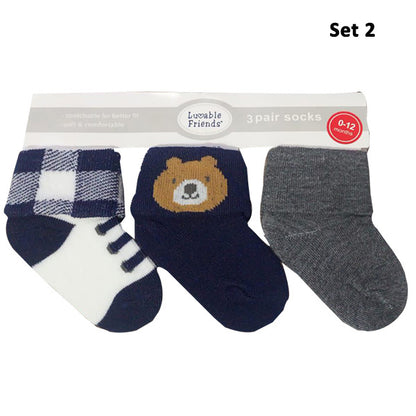 The Luvable Baby 3-Pair Socks Gift Set by Hudson includes three pairs of soft and stretchy fabric socks, ideal for babies aged 0-12 months. The set features a checkered black-and-white sock, a navy blue sock with a brown bear face, and a plain gray sock, all designed to stay on snugly.