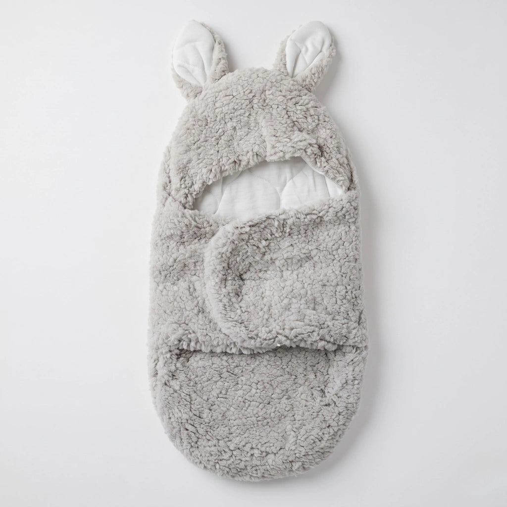 A light gray plush baby bootie with bunny ears on the hood, shown flat against a clean white background.