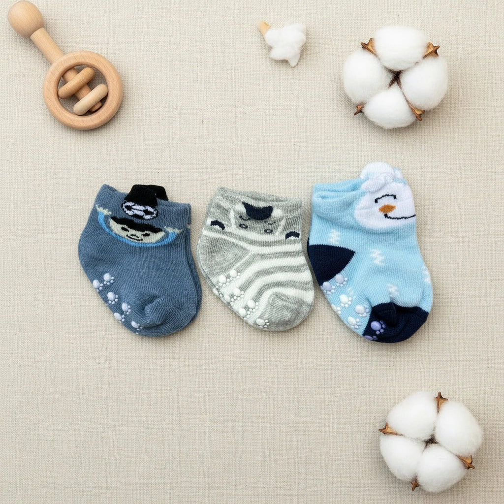 Three pairs of baby socks with animal designs on a white background