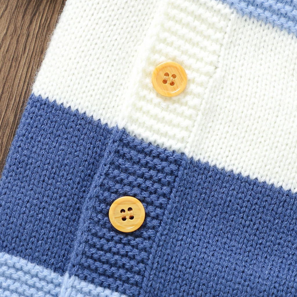 Blue - Close-up of a knitted fabric with blue and white stripes and yellow buttons.