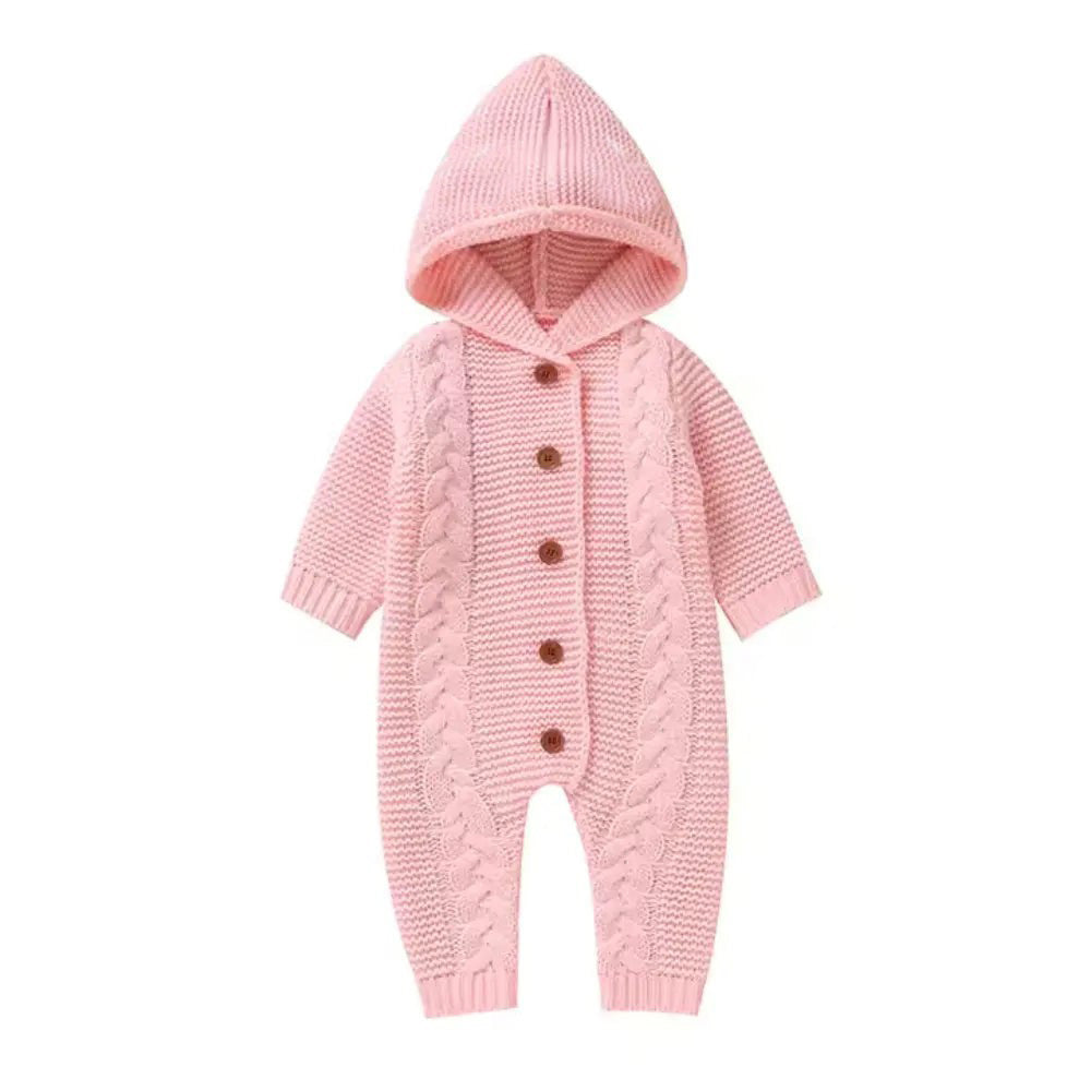 Introducing the Alaya Junior Baby Girl/Boy Knitted Pattern Hooded Jumpsuit: a charming pink, gender-neutral design with a button-down front. This jumpsuit boasts a stylish cable knit pattern along the sides and ribbed cuffs, crafted from soft, breathable fabric to ensure comfort for your little one.