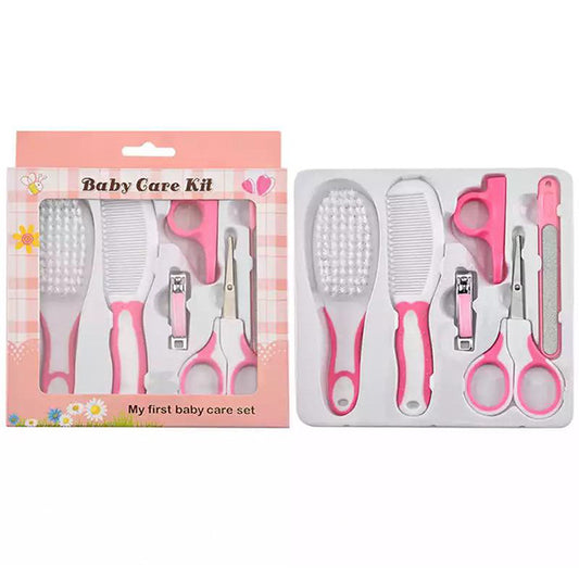 The FAGINEY Baby Care Kit by Alaya Junior, featuring a pink theme, includes essential baby care tools such as a soft hair brush, comb, nail clippers, scissors, and a nail file. These items are neatly arranged in a white tray beside their packaging labeled "My first baby care set.