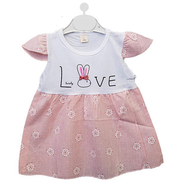 Introducing the "Love Bunny Summer Frock" by Alaya Junior, a delightful baby dress featuring a white top with the word "LOVE" and an adorable illustration of a bunny's head. The bottom part showcases a beautiful pink floral pattern, matching the short sleeves also adorned with a similar floral design. This charming dress is perfect for newborn babies and comes displayed on a white hanger.